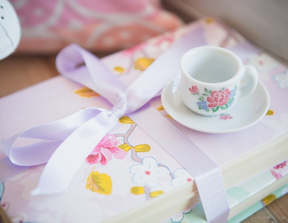 Pink and floral kids Bible for girls on a wooden desk, with colorful bookmarks, next to a notebook and a cup of tea — symbolizing faith, love, and spiritual growth for young girls.