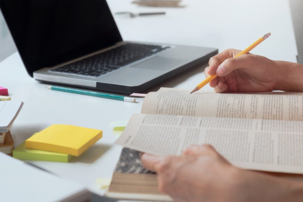 Open study Bible on a wooden desk with coffee and notes nearby