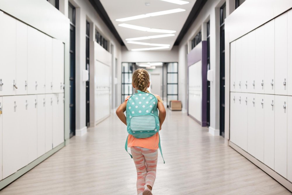 Child walking down a clean and bright school hallway, representing a safe and healthy learning environment
