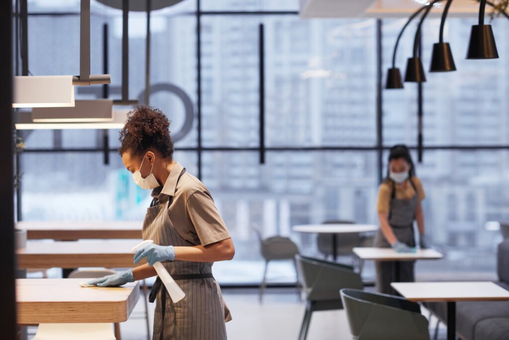 Two facility workers performing tasks diligently in a clean office environment