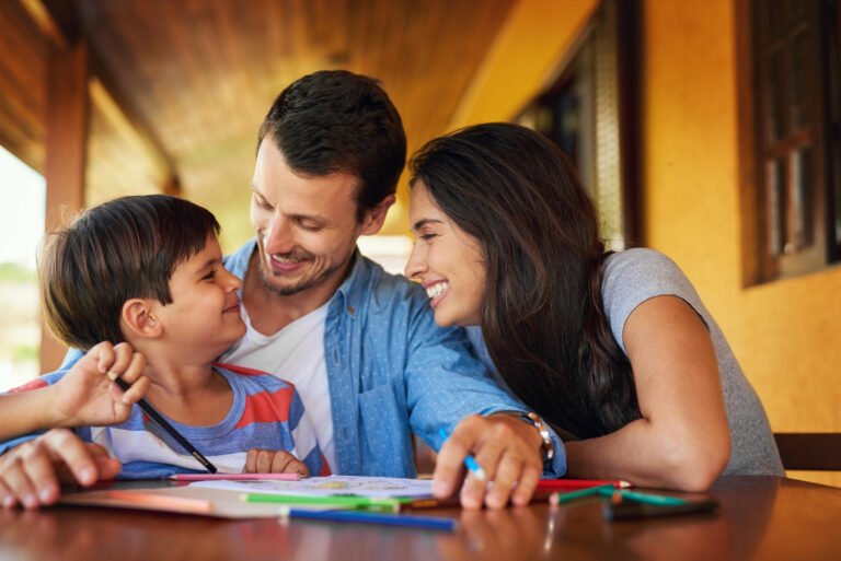 Smiling parents supporting their child’s emotional development through play and learning